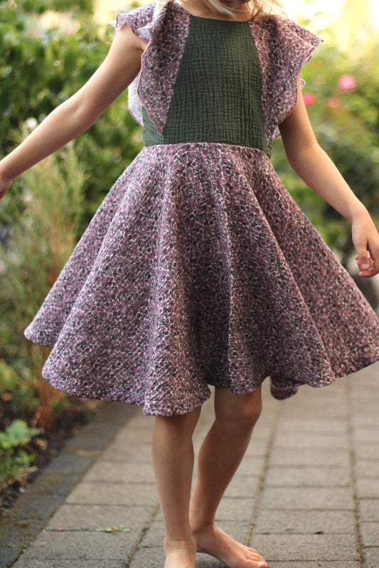 Genähtes Kleid nach dem Schnittmuster Flügelschlag mit breiten Volantärmeln, getragen von einem Mädchen im Freien