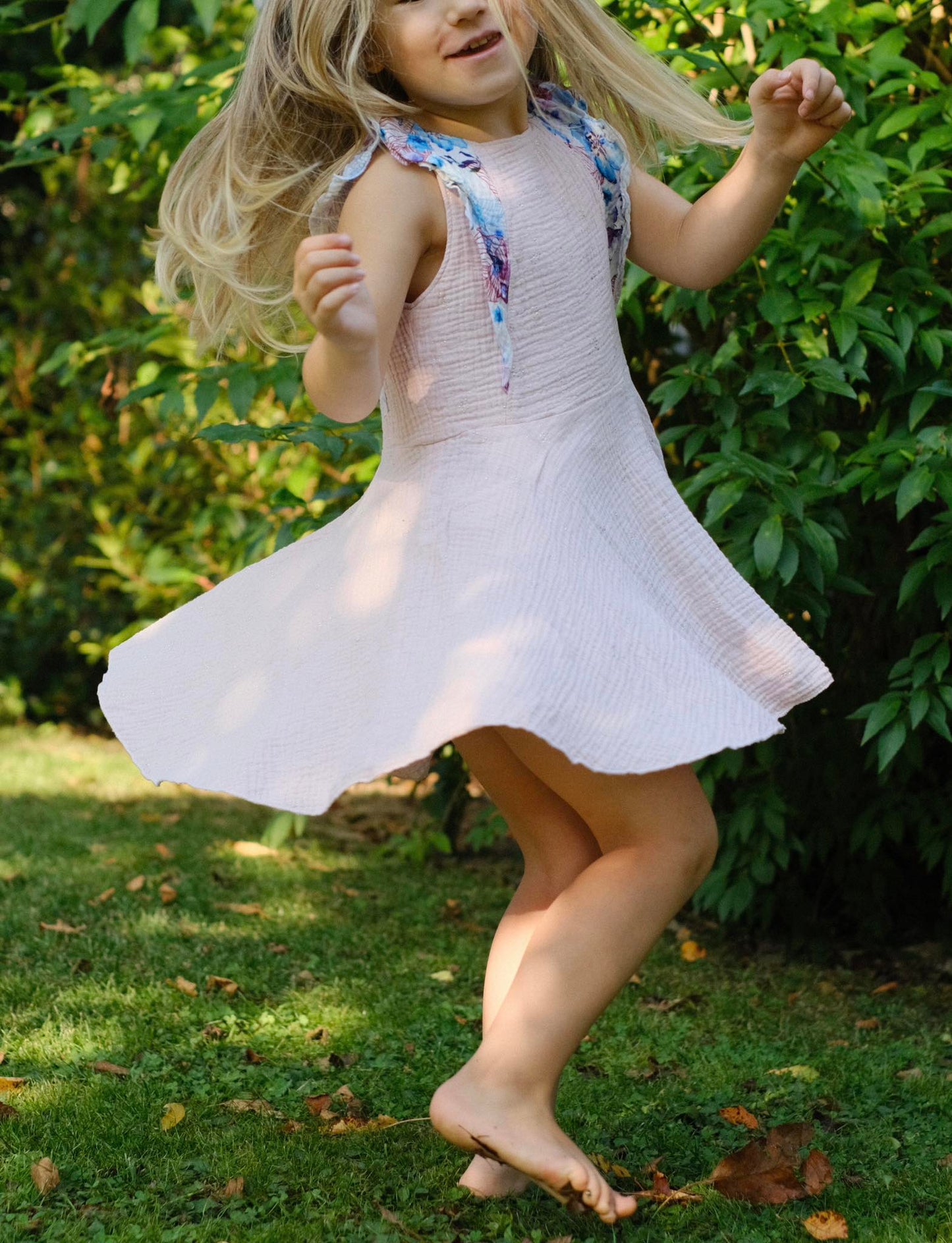 Mädchen dreht sich im Flügelschlag Kleid mit ausgestelltem Rock, das Kleid fliegt in der Bewegung mit